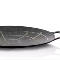 Black frying pan with textured surface on a white background