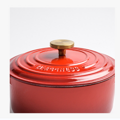 Red cookware with a gold lid on a white background