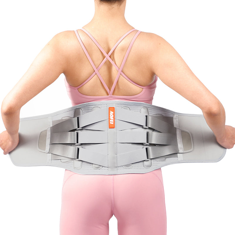 Person wearing a gray back brace with an orange label on a white background