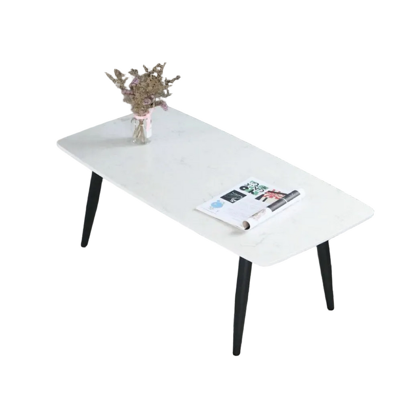 White coffee table with a magazine and vase in a living room setting