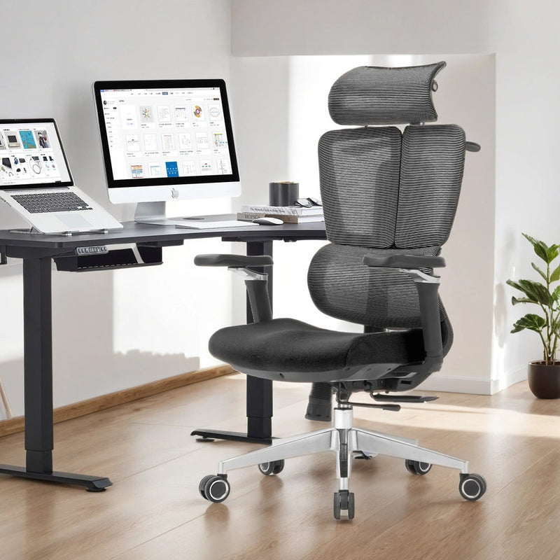 Ergonomic office chair in front of a desk with computer setup