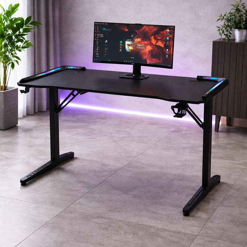 Black L-shaped gaming desk with RGB lighting in a room with plants and a curtain.